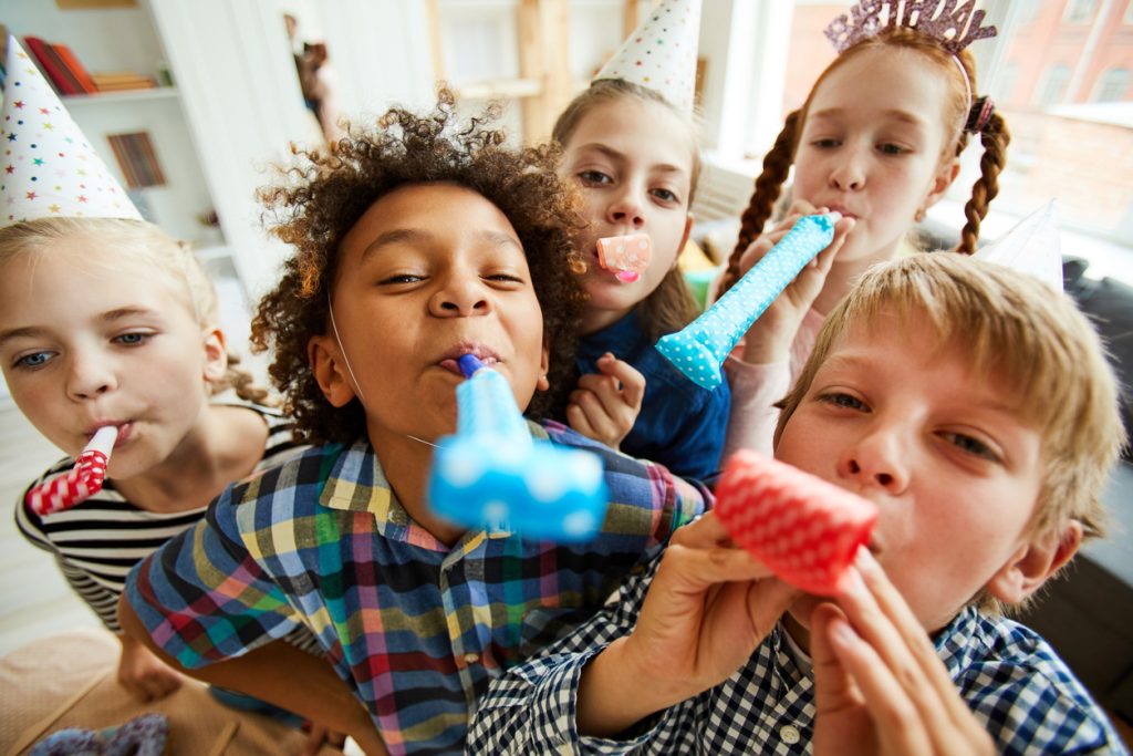 kids birthday party with kids blowing party horns