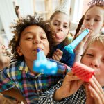 kids birthday party with kids blowing party horns